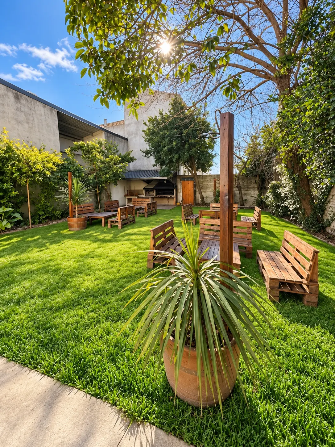 Jardín parquizado con parrilla y espacios de estar al aire libre