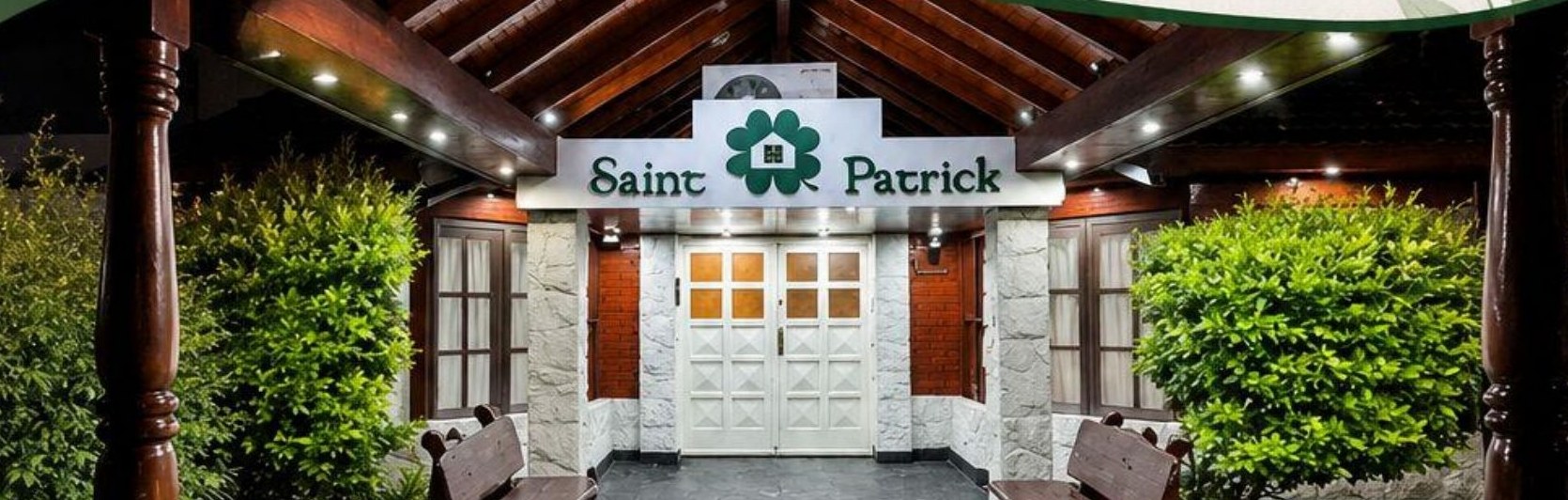 Ingreso principal de Saint Patrick, con galería de madera y jardín